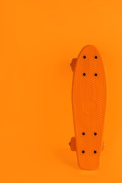Bright skateboard on orange background. Space for text