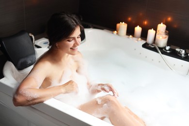 Happy beautiful woman taking bubble bath. Romantic atmosphere