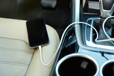 Photo of Mobile phone with charging cable in car
