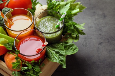Delicious vegetable juices and fresh ingredients on grey table