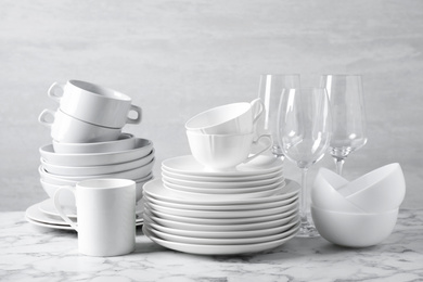 Set of clean dishware on marble table