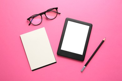Modern e-book reader, notebook, pencil and glasses on pink background, flat lay