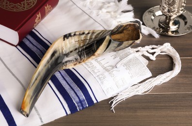 Shofar, Torah and tallit with text Pray For Peace To Jerusalem on wooden table. Rosh Hashanah holiday symbols