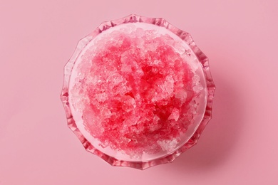 Shaving ice in glass dessert bowl on pink background, top view