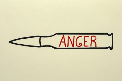 Drawing of bullet with word Anger on beige background, top view