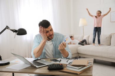 Overwhelmed man combining parenting and work at home