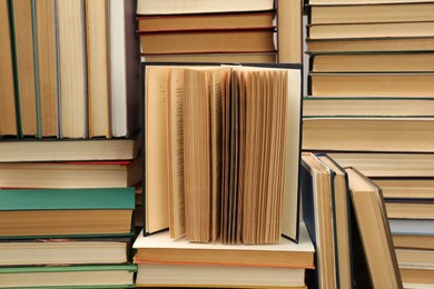 Many hardcover books as background. Library material