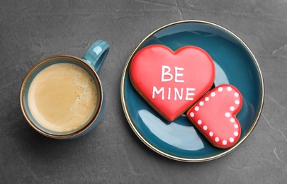Cup of coffee and heart shaped cookies on grey table, flat lay. Valentine's day breakfast