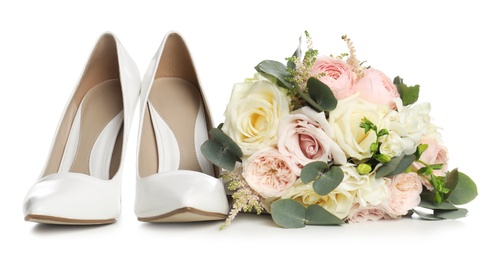 Pair of wedding high heel shoes and beautiful bouquet on white background