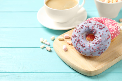Delicious glazed donuts on blue wooden table. Space for text