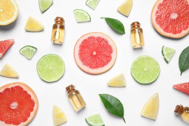 Flat lay composition with bottles of citrus essential oil on white background