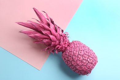 Photo of Pink pineapple on color background, top view. Creative concept