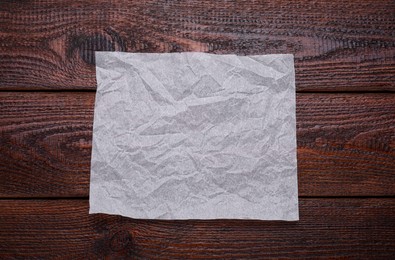 Sheet of baking paper on wooden table, top view