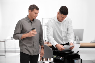Employees using new modern printer in office