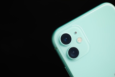 MYKOLAIV, UKRAINE - JULY 9, 2020: New modern Iphone 11 Green on black background, closeup. Space for text