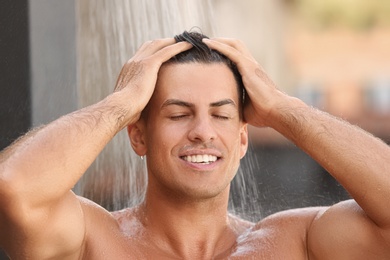 Man washing hair in outdoor shower on summer day, closeup