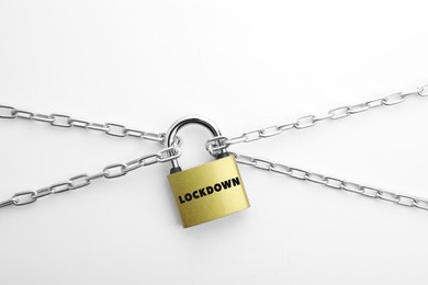 Concept of lockdown due to Coronavirus pandemic. Steel padlock and chain isolated on white, top view