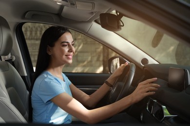Young woman using navigation system while driving car