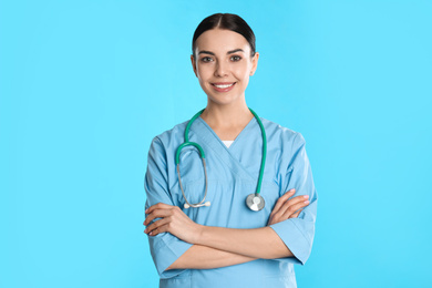 Photo of Portrait of young doctor with stethoscope on blue background