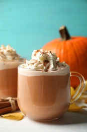 Delicious pumpkin latte on white table, closeup