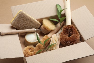 Cardboard box with eco friendly products on craft paper, closeup