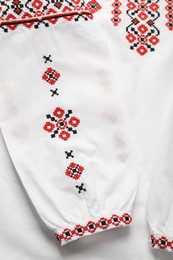 Photo of Beautiful white shirt with red Ukrainian national embroidery, top view