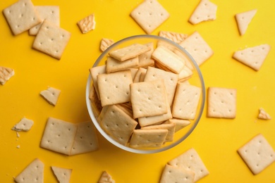 Delicious crackers on yellow background, flat lay