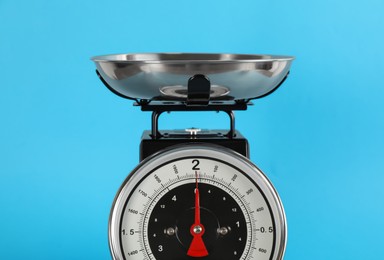 Retro mechanical kitchen scale on light blue background, closeup