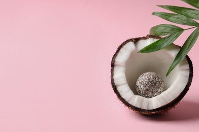 Composition with delicious vegan candy ball and coconut on pink background. Space for text