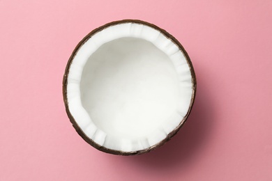 Fresh coconut half on pink background, top view