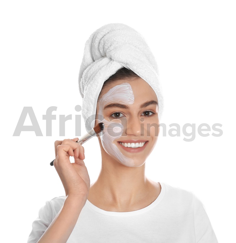 Photo of Happy young woman applying organic mask on her face against white background