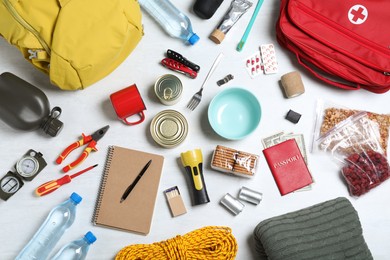 Disaster supply kit for earthquake on white wooden table, flat lay