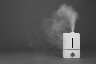 Modern air humidifier on grey background. Space for text