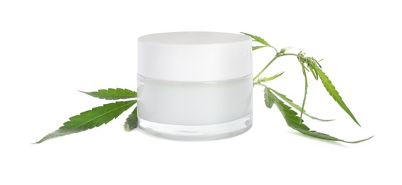 Jar of hemp cream and green leaves on white background. Natural cosmetics