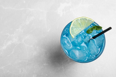 Tasty Blue Lagoon cocktail on light grey table, top view. Space for text