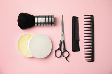 Professional hairstyling tools on pink background, flat lay
