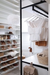 Dressing room interior with clothes rack and collection of stylish shoes