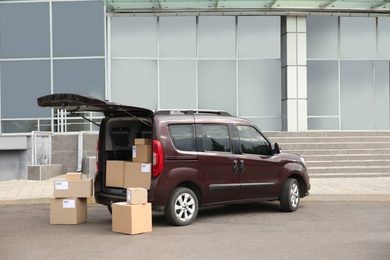 Courier car with packages parked near office building