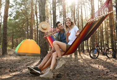 Couple resting in hammock outdoors on summer day