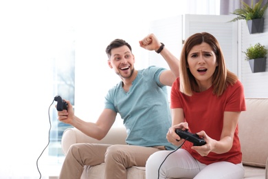Happy couple playing video games in living room
