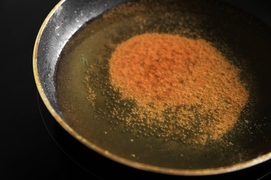 Frying pan with used cooking oil on stove, closeup