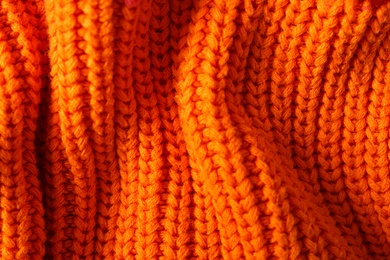 Texture of knitted orange fabric as background, closeup