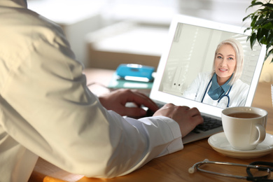 Woman using laptop for online consultation with mature female doctor, closeup 