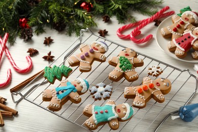 Making homemade Christmas cookies. Gingerbread people and festive decor on white wooden table
