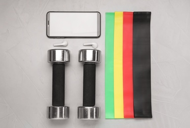 Photo of Flat lay composition with fitness elastic bands on grey background