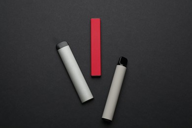 Disposable electronic smoking devices on black background, flat lay
