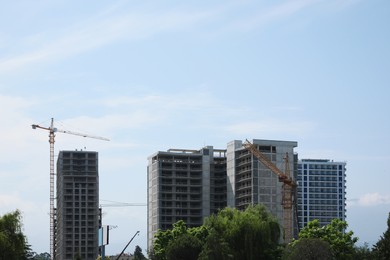 Construction site with tower cranes near unfinished buildings