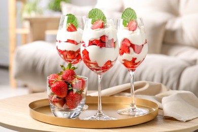 Delicious strawberries with whipped cream on wooden table indoors