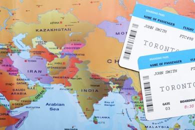 Avia tickets on world map, flat lay. Travel agency concept
