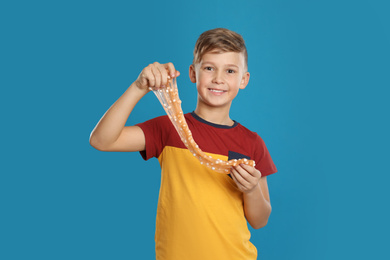 Photo of Preteen boy with slime on blue background